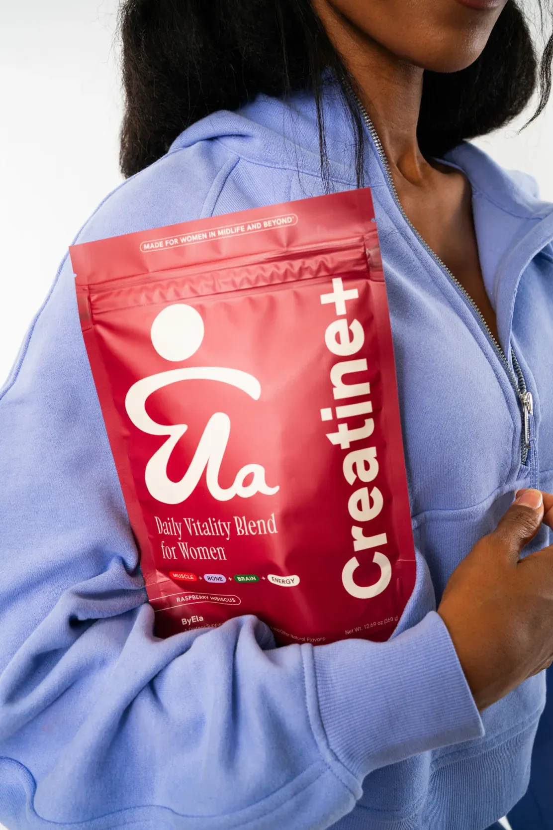 Woman holding a ByEla Creatine+ pouch