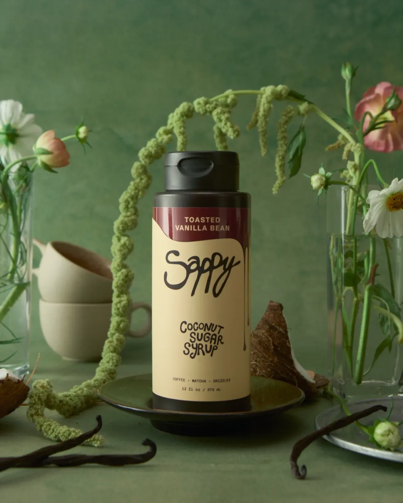 Sappy bottle on a green table with flowers