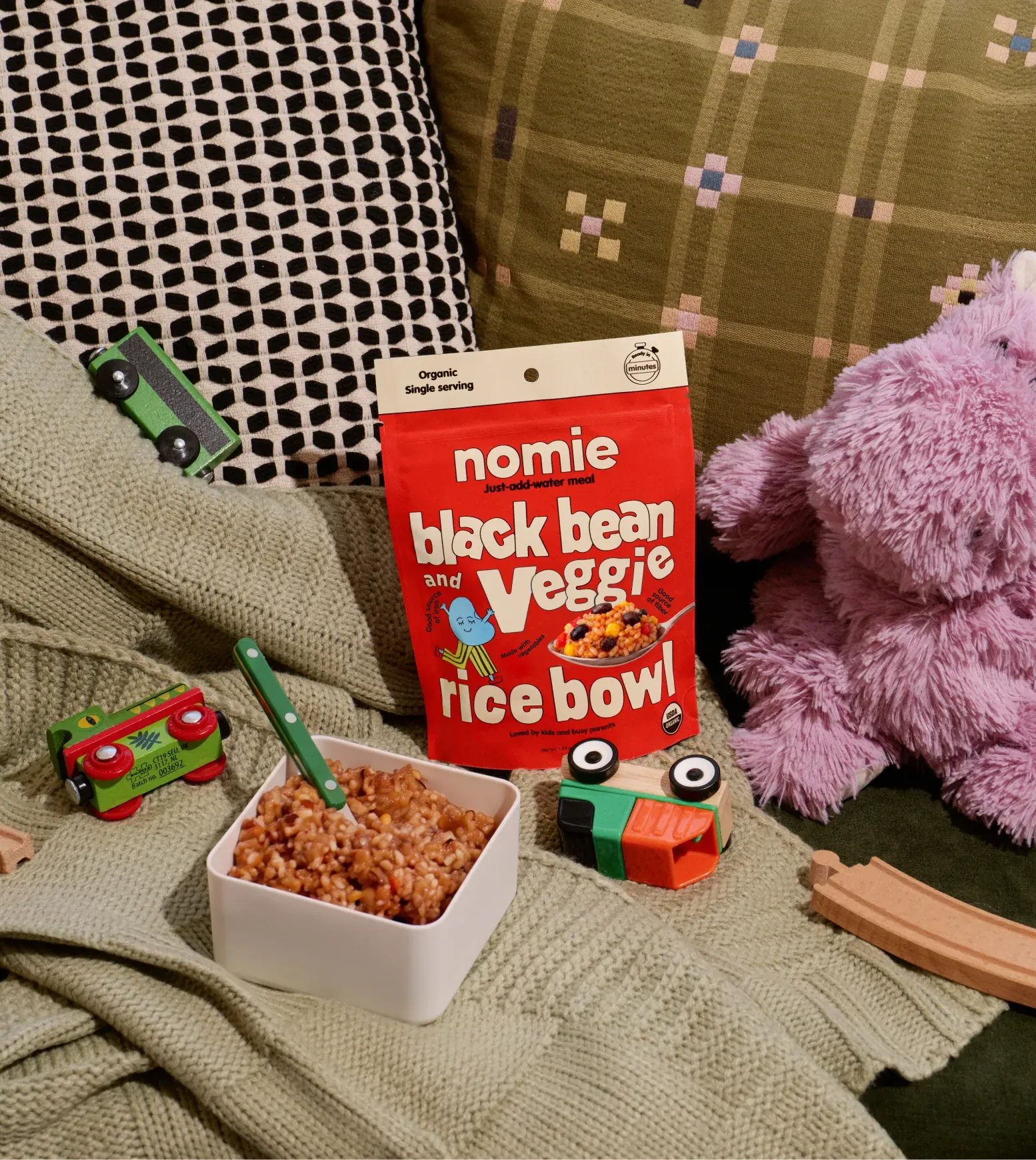 Nomie black bean veggie rice bowl with toys and stuffed animals