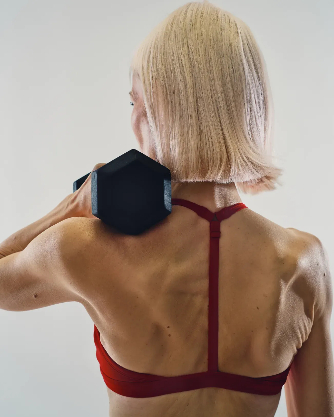 Woman holding a dumbbell on her shoulder